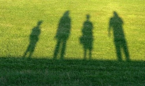 Sombras de crianças na grama.