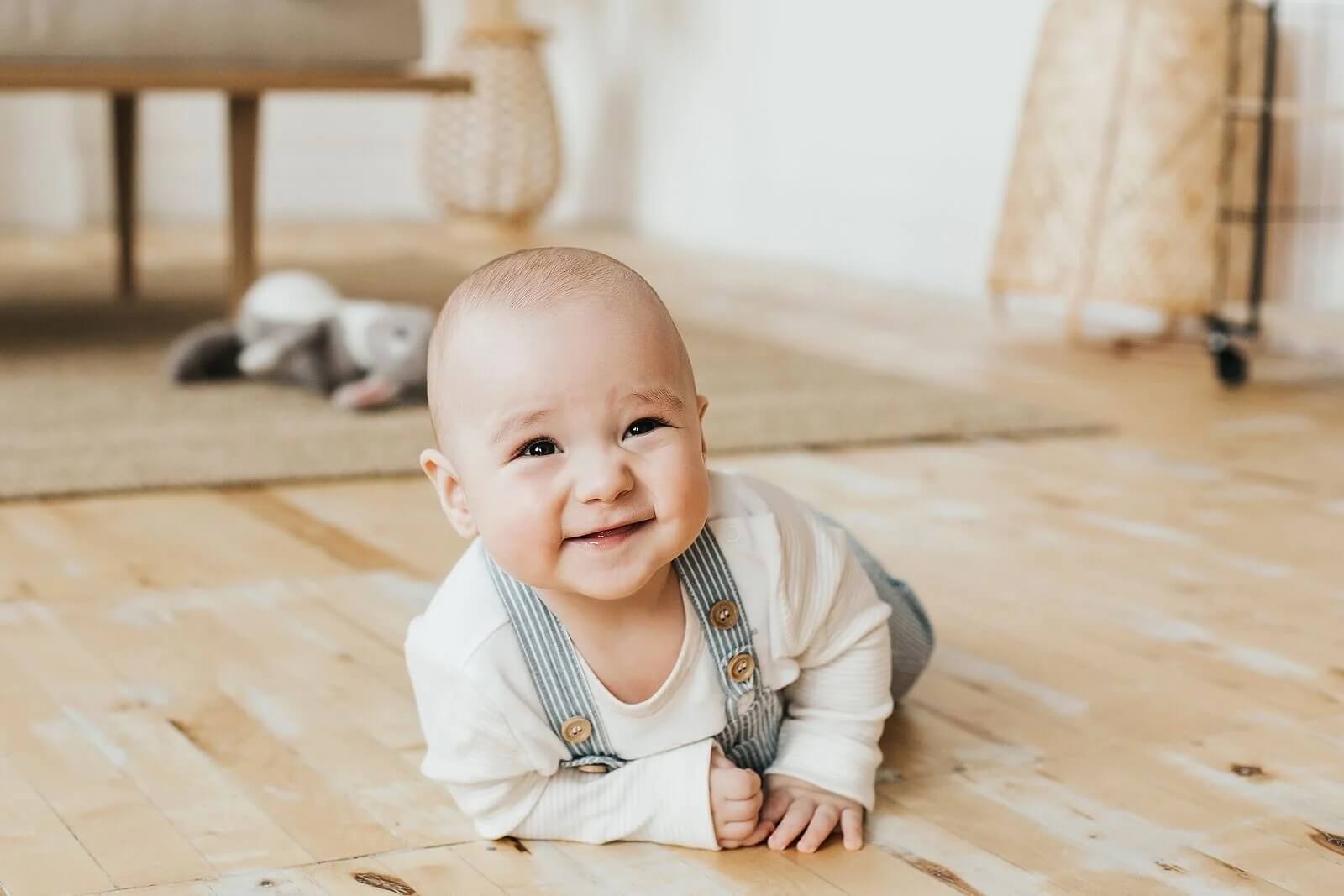 Bebê feliz enquanto engatinha e aprende a ter uma boa higiene postural.