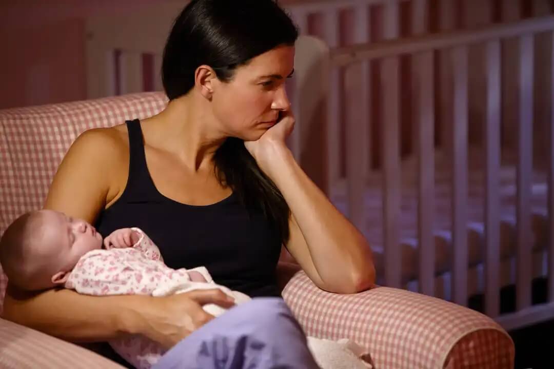 Mulher tentando ajudar seu bebê a dormir à noite.