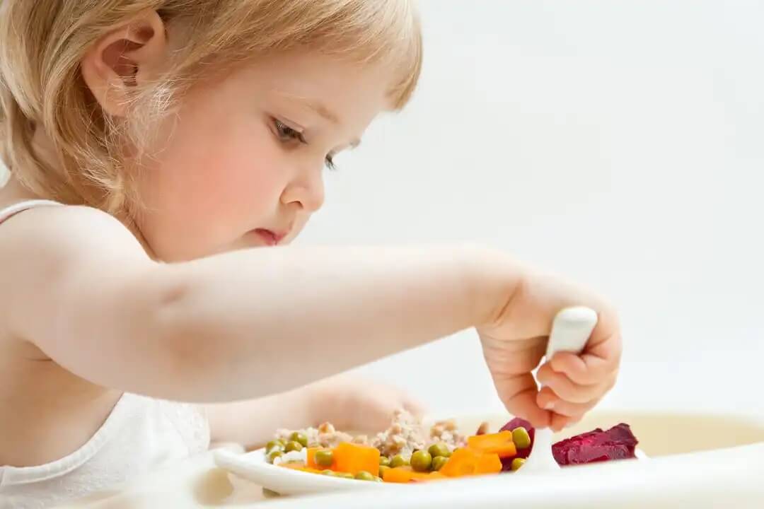 Menina comendo saudável para prevenir transtornos alimentares.