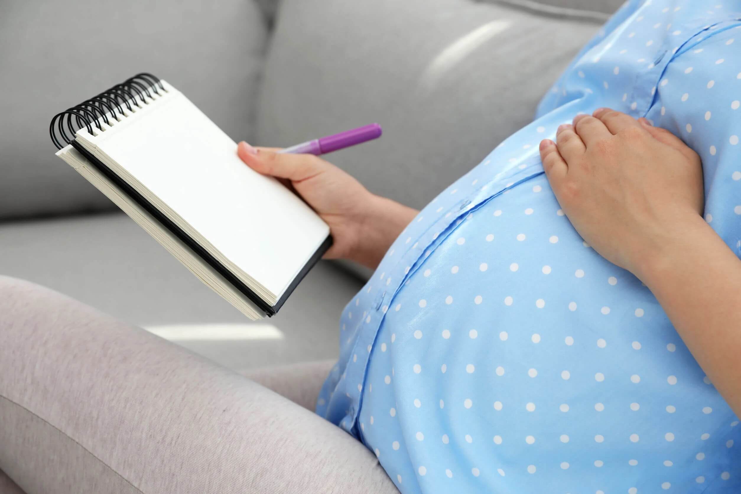 Mulher grávida pensando e escrevendo os nomes dos bebês élficos.