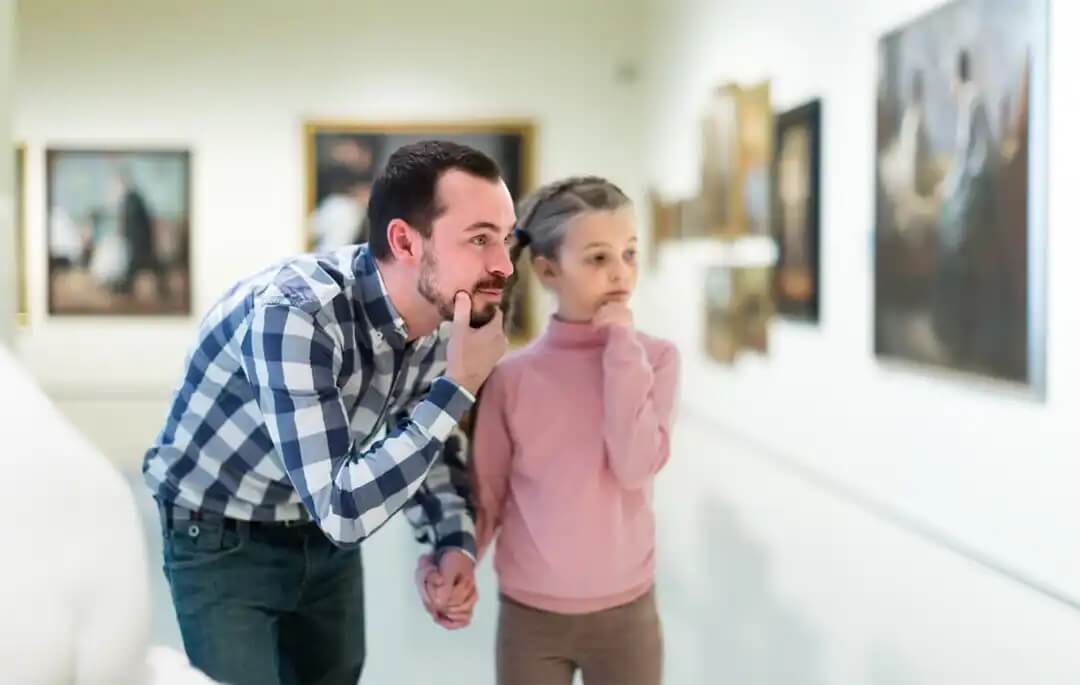 Pai e filha visitando um museu durante a Semana Internacional de Educação Artística.