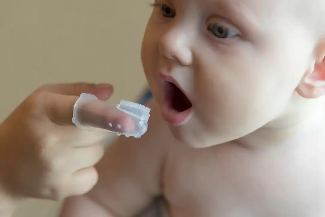 Pais escovando os dentes do bebê.