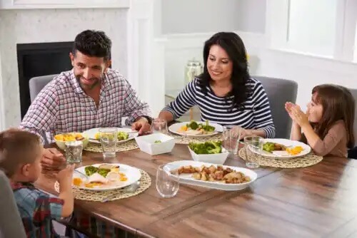 Família comendo em casa graças às dicas para planejar um cardápio saudável.