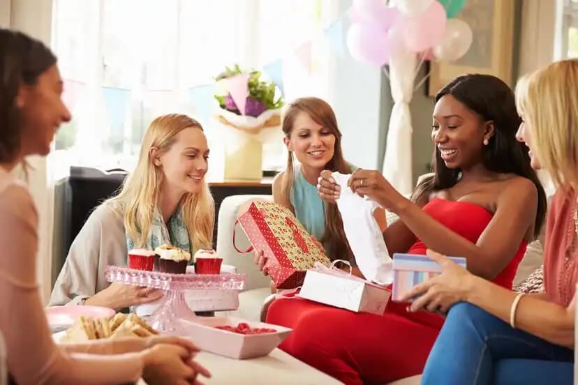 Amigas em um chá de bebê distribuindo presentes.