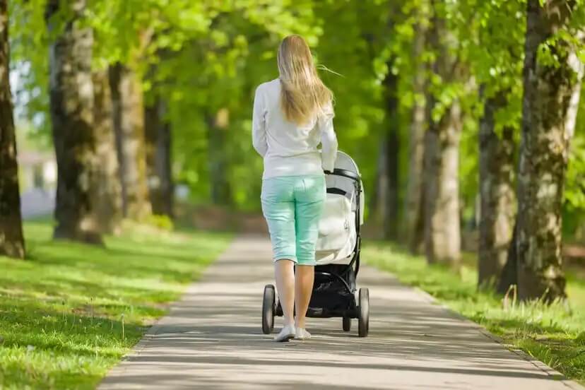 Mãe dando um passeio com seu bebê no parque.