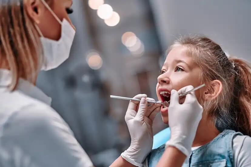 Menina no dentista para descobrir os maus hábitos para os dentes das crianças.