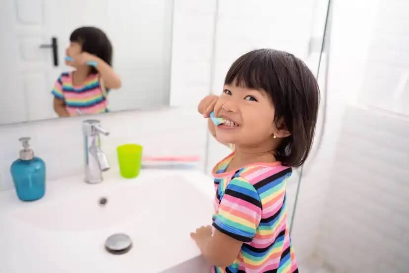 Menina escovando os dentes.
