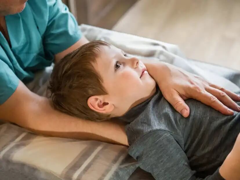 Criança em fisioterapia infantil com dor de pescoço.