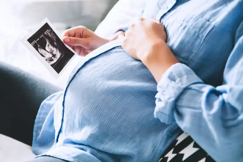 Mulher grávida olhando para a ultrassonografia do filho.